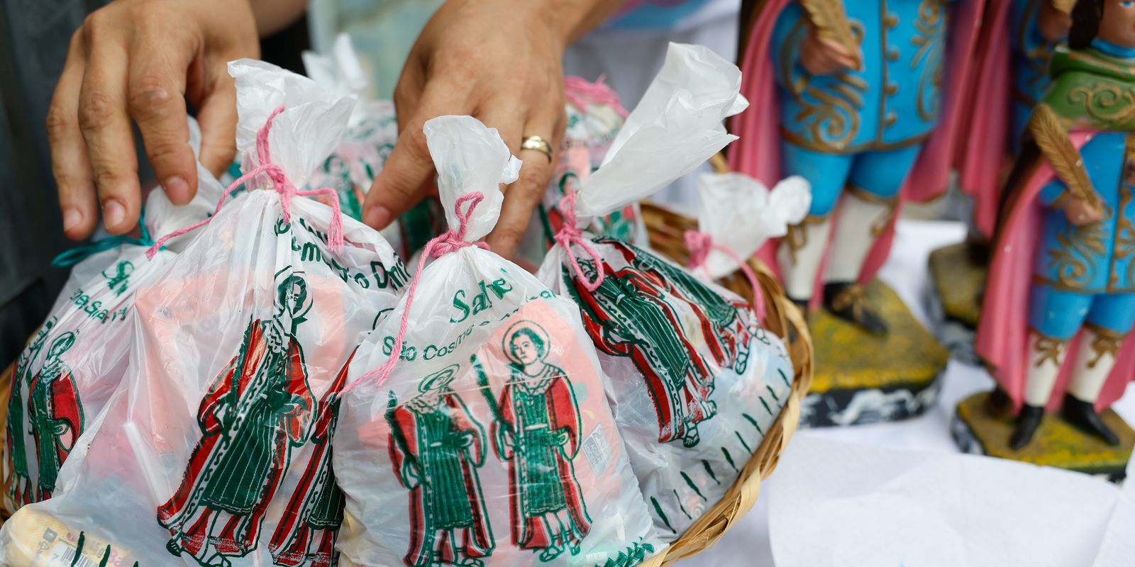 Celebrado neste domingo, dia é marcado por missas e festividades em terreiros, além da tradicional distribuição de doces para crianças.